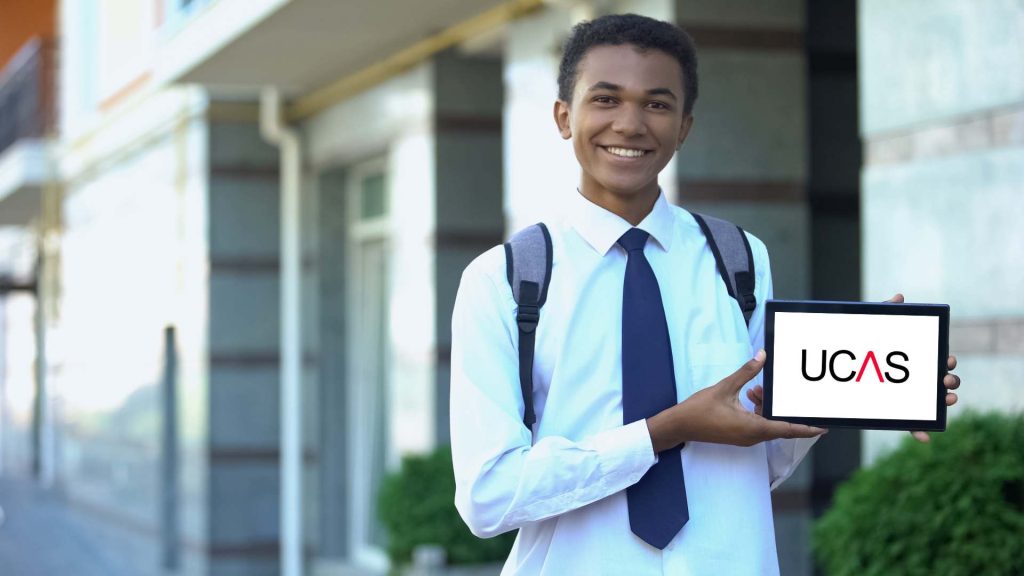Young student showing a ipad screen with a UCAS logo for UK universities applications