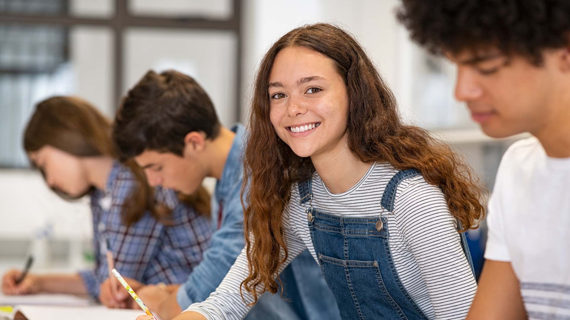 Happy high school girl studying in class, preparing for UK universities as an international student